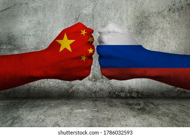 Concept Of The Conflict Between Russia And The Peoples Republic Of China With Two Opposing Fists In Front Of A Wall