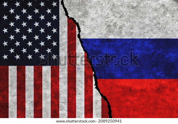 Concept of a conflict between USA and Russia\
with painted flags on a wall with a\
crack