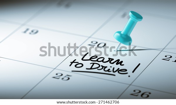 Concept\
image of a Calendar with a blue push pin. Closeup shot of a\
thumbtack attached. The words Learn to Drive written on a white\
notebook to remind you an important\
appointment.