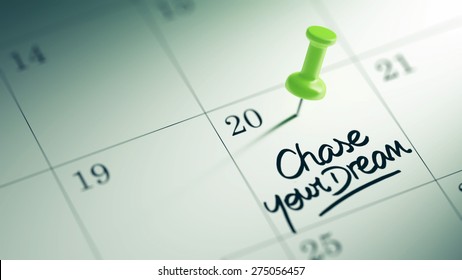 Concept image of a Calendar with a green push pin. Closeup shot of a thumbtack attached. The words Chase your dream written on a white notebook to remind you an important appointment.