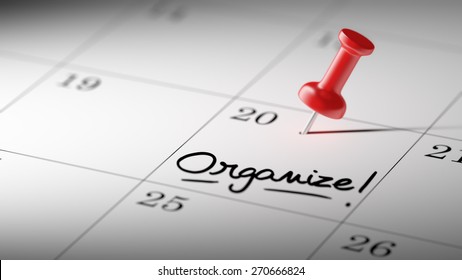 Concept image of a Calendar with a red push pin. Closeup shot of a thumbtack attached. The words Organize written on a white notebook to remind you an important appointment.
