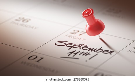Concept image of a Calendar with a red push pin. Closeup shot of a thumbtack attached. The words September 11th written on a white notebook to remind you an important appointment.