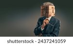 A conceptual image of an elderly businessman wearing a dark suit and holding up glasses in contemplation. His head is a jumble of puzzle pieces which are all mixed up, with an eye, ear, mouth etc