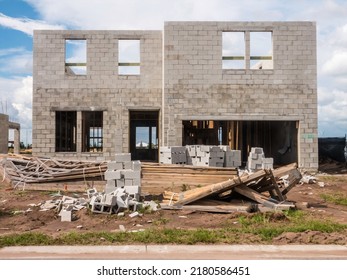 Concrete Blocks And Wooden Roof Trusses In Front Of Concrete Shell Of House Under Construction In A Suburban Development In Southwest Florida. Light Digital Oil-painting Effect, 3D Rendering.