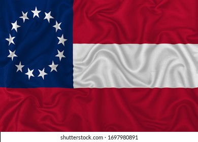 Confederate States of America flag (1861-1865) on wavy silk textile fabric background.