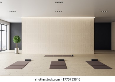 Contemporary interior of yoga classroom with mats and blank wall. Healthy lifestyle concept. Mock up. 3D Rendering - Powered by Shutterstock