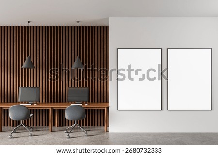 Contemporary office interior featuring two vertical poster mockups on white wall, wood slat paneling, and workstations with modern decor. 3D Rendering