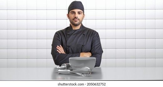 Cook Chef In Black Coat, Kitchen Interior Background. Young Handsome Man With Beard And Cup Standing With Crossed Hands, Kitchenware On The Counter, White Tiled Wall. 3d Illustration