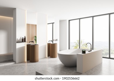 Corner of a comfortable bathroom with white and wooden walls, concrete floor, two round sinks and a cozy bathtub. Window with a blurry tropical view. 3d rendering