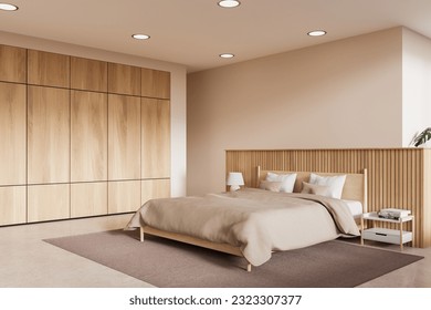 Corner of modern bedroom with beige walls, concrete floor, comfortable king size bed with beige cover standing on brown carpet and wooden wardrobe. 3d rendering - Powered by Shutterstock