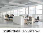 Corner of modern Industrial style open space office with white walls, concrete floor, rows of computer tables and panoramic windows with blurry cityscape. 3d rendering