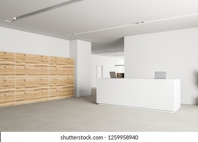 Corner Of Office Reception Area With White Walls, Carpet On Floor, White Reception Desk With Laptops And Wooden Lockers. Office In The Background. 3d Rendering