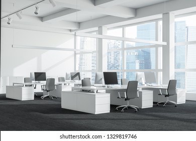 Corner of open space office with white walls, carpeted floor, large windows and rows of white computer tables with black chairs. 3d rendering