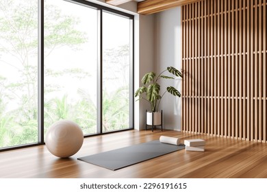 Corner of panoramic yoga studio with white and wooden walls, wooden floor, yoga mat and white fitball. 3d rendering - Powered by Shutterstock