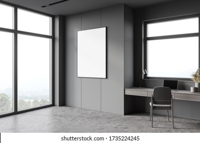 Corner Of Stylish Home Office With Grey Walls, Concrete Floor, Comfortable Computer Table With Gray Chair Near Window With Blurry Mountain View. Mock Up Poster. 3d Rendering