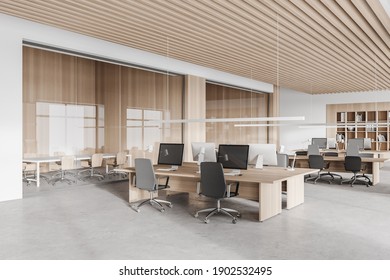 Corner of stylish open space office with white and wooden walls, concrete floor, row of computer tables and meeting rooms to the left. 3d rendering