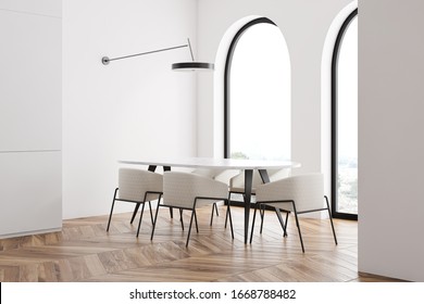 Corner Of Stylish Panoramic Dining Room With White Walls, Wooden Floor, Arched Windows And Marble Table With White Armchairs. 3d Rendering