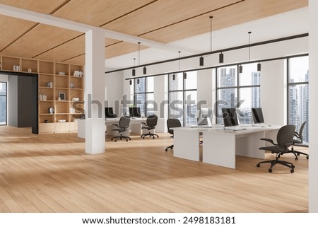 Corner view of office interior with pc computers on shared desk, hardwood floor. Coworking space and shelf with decoration. Panoramic window on Bangkok skyscrapers. 3D rendering