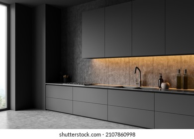 Corner view on dark kitchen room interior with cupboard, panoramic window, electric cooker, grey wall, sink, liquid soap and concrete floor. Concept of minimalist design. 3d rendering