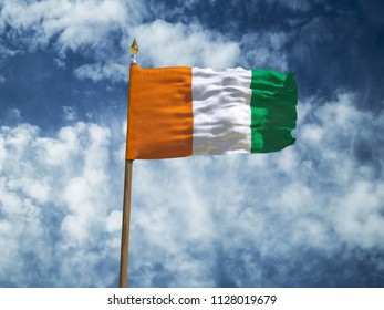 Cote d'Ivoire flag Silk waving flag of Ivory Coast made transparent fabric with wooden flagpole gold spear on background blue sky white smoke clouds real retro photo Countries of world 3d illustration - Powered by Shutterstock - Get 15% off with code: PIKWIZARD15