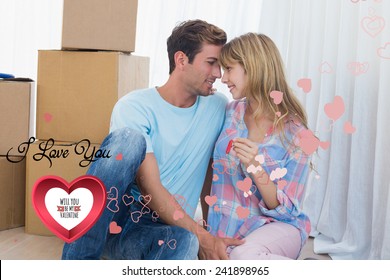 Couple holding new house key against cardboard boxes against cute valentines message - Powered by Shutterstock