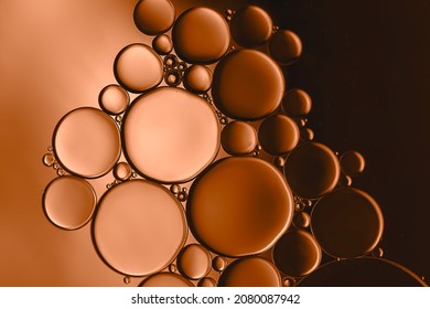 A created abstract diagram produced by adding oil droplets to water and resulting in an interesting collection of different sized bubbles highlighted by adding copper-bronze coloured lighting.