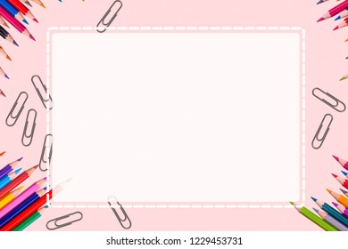 Creative blank space message paper decorated with colorful painting pencils on soft pink background