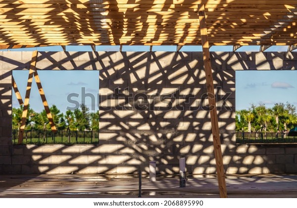 Crisscrossing\
shadows of roof beams across concrete wall in single-family house\
under construction in a suburban development in southwest Florida.\
Digital oil-painting effect, 3D\
rendering.