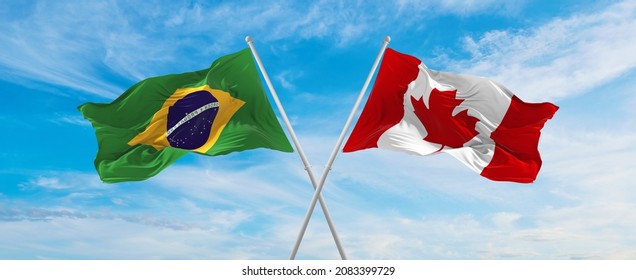 crossed national flags of Brazil  and canada flag waving in the wind at cloudy sky. Symbolizing relationship, dialog, travelling between two countries. Copy space. 3d illustration