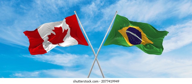 crossed national flags of Canada and Brazil flag waving in the wind at cloudy sky. Symbolizing relationship, dialog, travelling between two countries. Copy space. 3d illustration