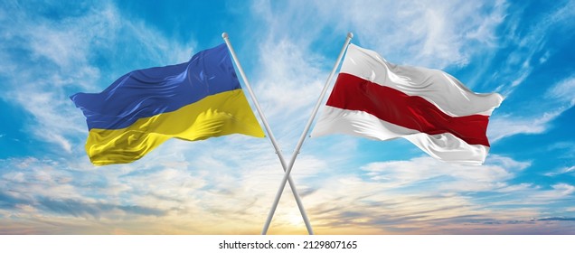 crossed national flags of Ukraine and Belarus flag waving in wind at cloudy sky. Symbolizing relationship, dialog, travelling between two countries. Copy space. 3d illustration