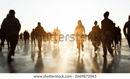 Crowd walking towards bright light at sunset