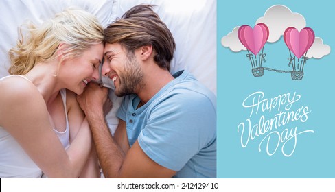 Cute couple relaxing on bed smiling at each other against cute valentines message - Powered by Shutterstock