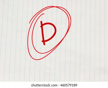 D Grade Written In Red On Notebook Paper