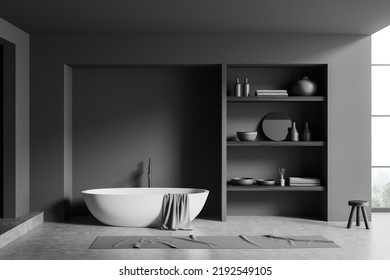 Dark Bathroom Interior With Bathtub, Shelf With Art Decoration And Bath Accessories, Foot Towel On Grey Concrete Floor. Panoramic Window On Countryside. Mockup Empty Wall. 3D Rendering