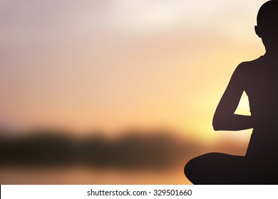 dark black silhouette of asian woman in yoga over blurred sunset golden sky light color background for healthy life concept.