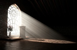 A Dark Church Interior Lit By Suns Rays Penetrating Through A Glass Window In The Pattern Of A Crucifix Shining On A Speech Pulpit - 3D Render