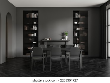 Dark Dining Room Interior With Table And Chairs, Shelf With Books And Art Decoration. Fireplace, Window And Black Hardwood Floor. 3D Rendering