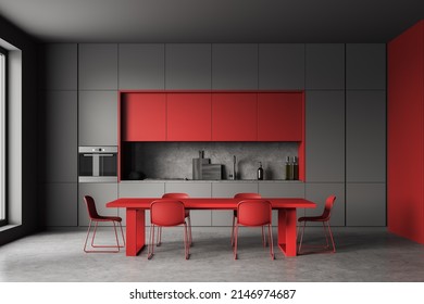 Dark Kitchen Interior With Red Chairs And Dining Table, Grey Concrete Floor. Eating Room With Kitchenware, Window And Minimalist Cooking Space. 3D Rendering