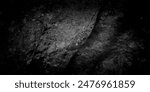 A dark, textured rock surface with shades of black and gray, creating a dramatic and mysterious atmosphere. Ideal for backgrounds or designs needing a bold, moody, and unique aesthetic