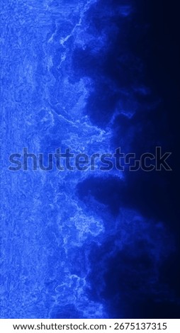 Deep blue abstract texture mimics a glowing coastline or electric wave crashing in darkness.