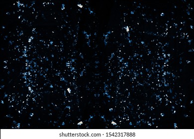 Dense Chunky Blue Glitter Pieces Of Various Sizes Isolated On A Black Background.