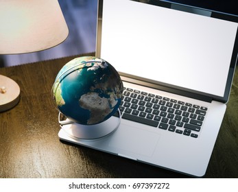 Desktop globe on the modern silver laptop. Elements of this image furnished by NASA. 3d rendering