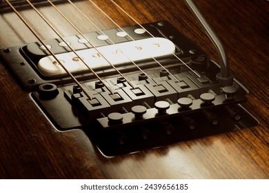 A detailed close-up photography focusing on the bridge, pickups, strings, and fine craftsmanship of an electric guitar against a wooden background. Perfect details for music enthusiasts. - Powered by Shutterstock