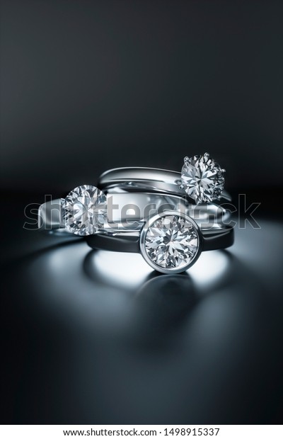 Diamond\
rings on a black background - 3D\
illustration