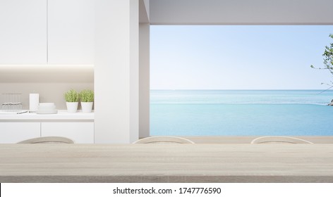 Dining Room Near Modern Kitchen In Luxury Beach House. Home Interior 3d Rendering With Empty Wooden Top Table And Sea View For Product Display.