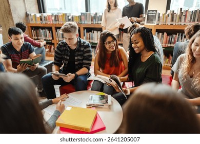 Diverse group of young adults studying in a library. Students reading books, discussing, and collaborating. Engaged in learning, sharing ideas, and teamwork. Diverse people in library. - Powered by Shutterstock - Get 15% off with code: PIKWIZARD15