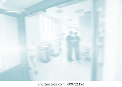 Doctor Standing On Corridor With Open Door In Hospital