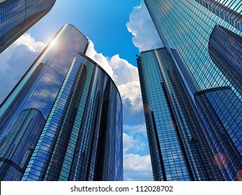 Downtown corporate business district architecture: glass reflective office buildings against blue sky with clouds and sun light