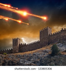 Dramatic background - old fortress, tower under attack. Dark stormy sky, asteroid, meteorite impact
